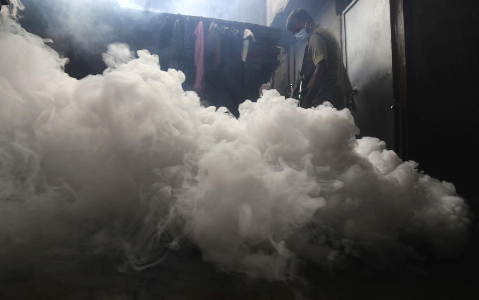 A civic worker fumigates a lane in Mumbai, India, Tuesday, Aug. 11, 2020. India has the third-highest coronavirus caseload in the world after the United States and Brazil. (AP Photo/Rafiq Maqbool)