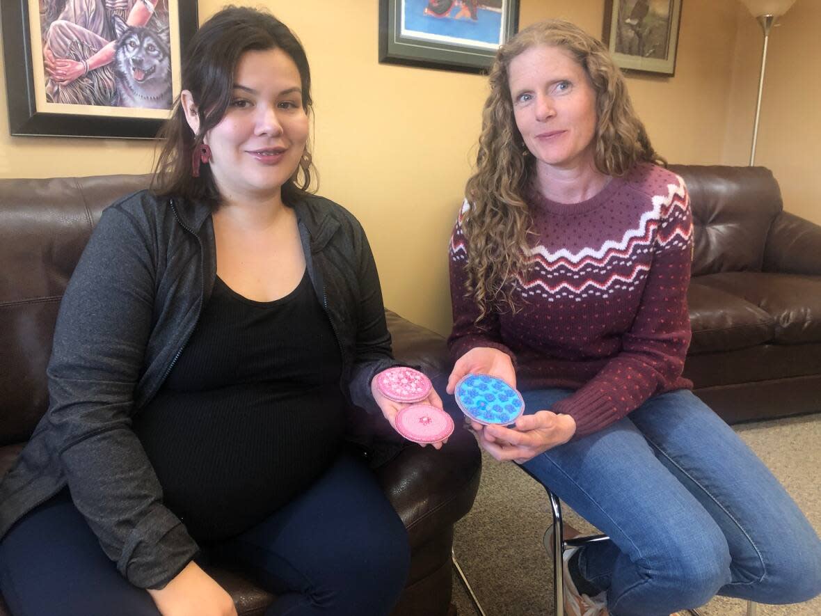 Artist Stormy Bradley, left, and Stephanie Coombs with the beadwork used in a new campaign in the Yukon promoting the HPV vaccine.  (Elyn Jones/CBC - image credit)