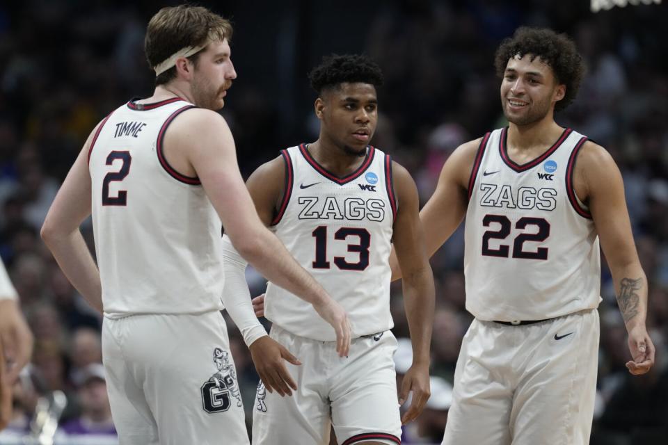 Gonzaga forward Drew Timme, left, guard Malachi Smith, center, and forward Anton Watson talk on the court.