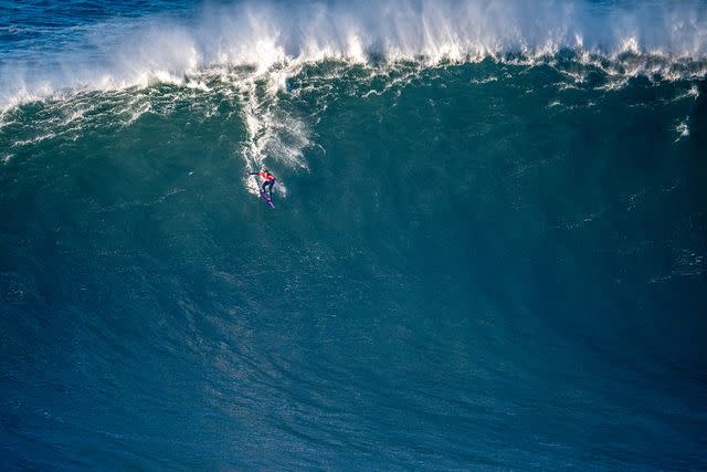 <p>Octavio Passos/Getty</p> Kai Lenny surfs in the Nazare Tow Surfing Challenge in Portugal on Dec. 31, 2021.