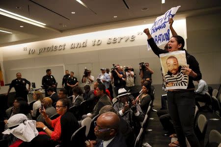 People stand on chairs in protest of the death of Ezell Ford, after the police commission walked out due to an audience disturbance, during a meeting of the Los Angeles Police Commission in Los Angeles, California June 9, 2015. REUTERS/Patrick T. Fallon