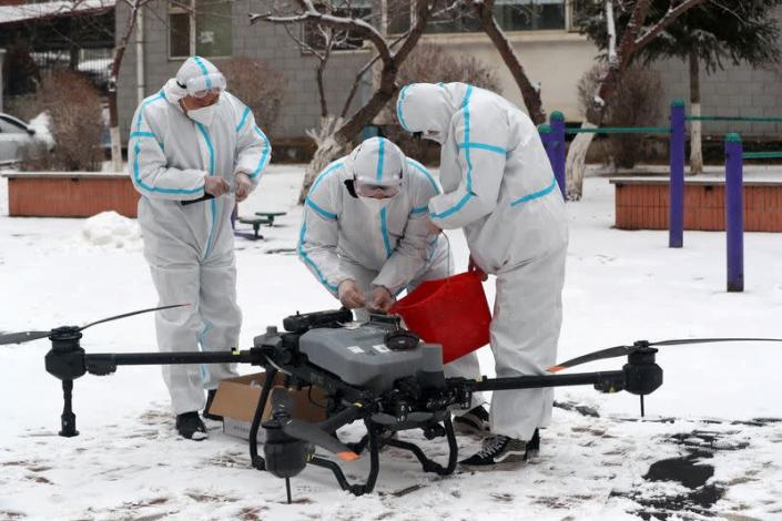 Workers prepare a drone to disinfect a residential compound under lockdown in Changchun