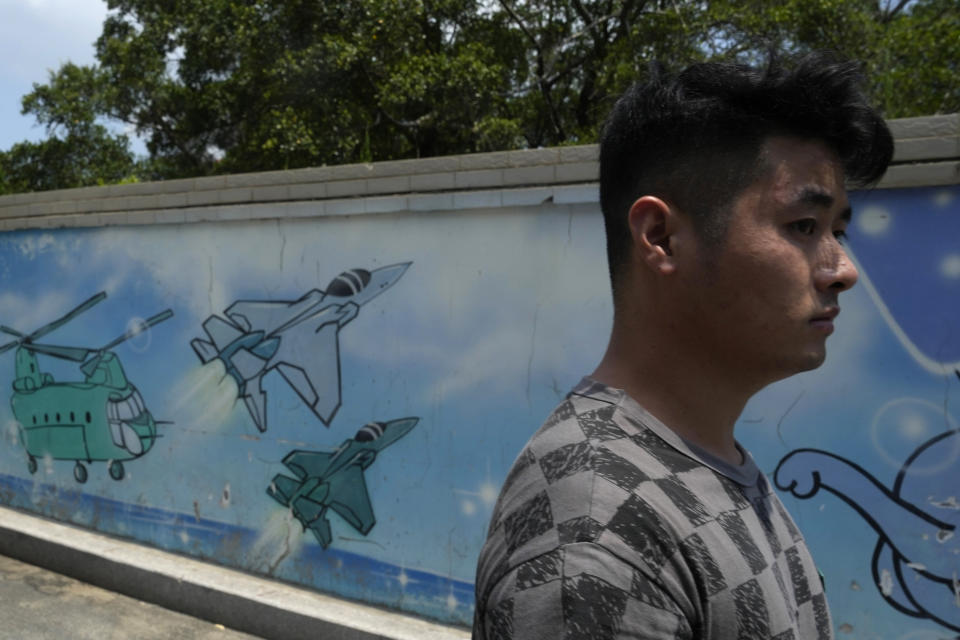 A man walks past a wall mural depicting military helicopter and fighter jets in Pingtan in eastern China's Fujian Province, Sunday, Aug. 7, 2022. Taiwan said Saturday that China's military drills appear to simulate an attack on the self-ruled island, after multiple Chinese warships and aircraft crossed the median line of the Taiwan Strait following U.S. House Speaker Nancy Pelosi's visit to Taipei that infuriated Beijing. (AP Photo/Ng Han Guan)