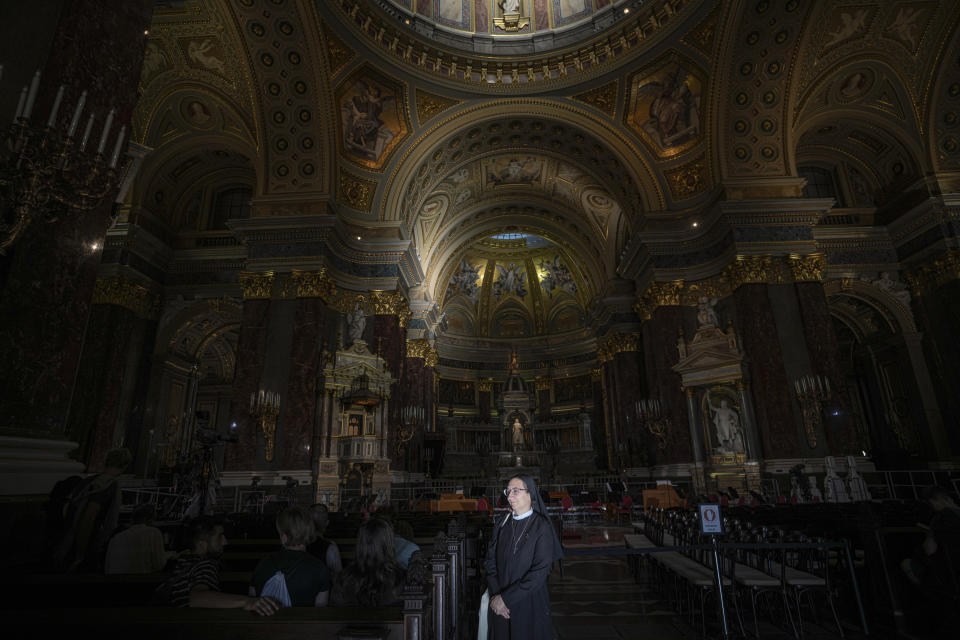 A nun is illuminated by sun beams inside the St. Stephen's Basilica in Budapest, Hungary, Friday, Sept. 10, 2021. Pope Francis is making his first foreign trip since undergoing intestinal surgery in July. His four-day visit to Hungary and Slovakia starting Sunday will not only test his health but also provide what may be one of the most awkward moments of his papacy — a meeting with Hungarian Prime Minister Viktor Orban, the sort of populist, right-wing leader Francis scorns. (AP Photo/Vadim Ghirda)