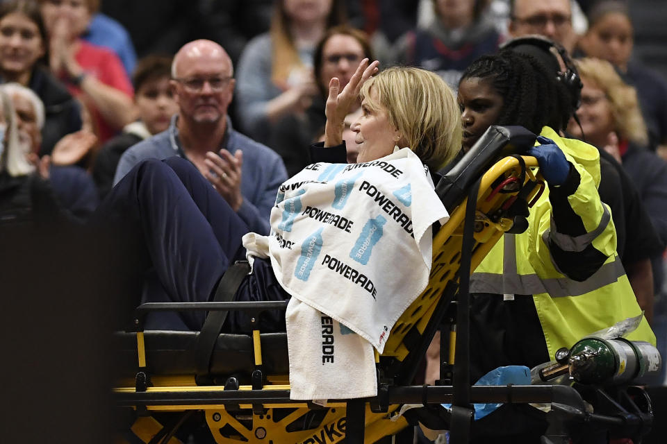 Associate Head Coach Chris Dailey waves from a stretcher before an NCAA basketball game against North Carolina State, Sunday, Nov. 20, 2022, in Hartford, Conn. Dailey experienced a medical emergency during the national anthem. (AP Photo/Jessica Hill)
