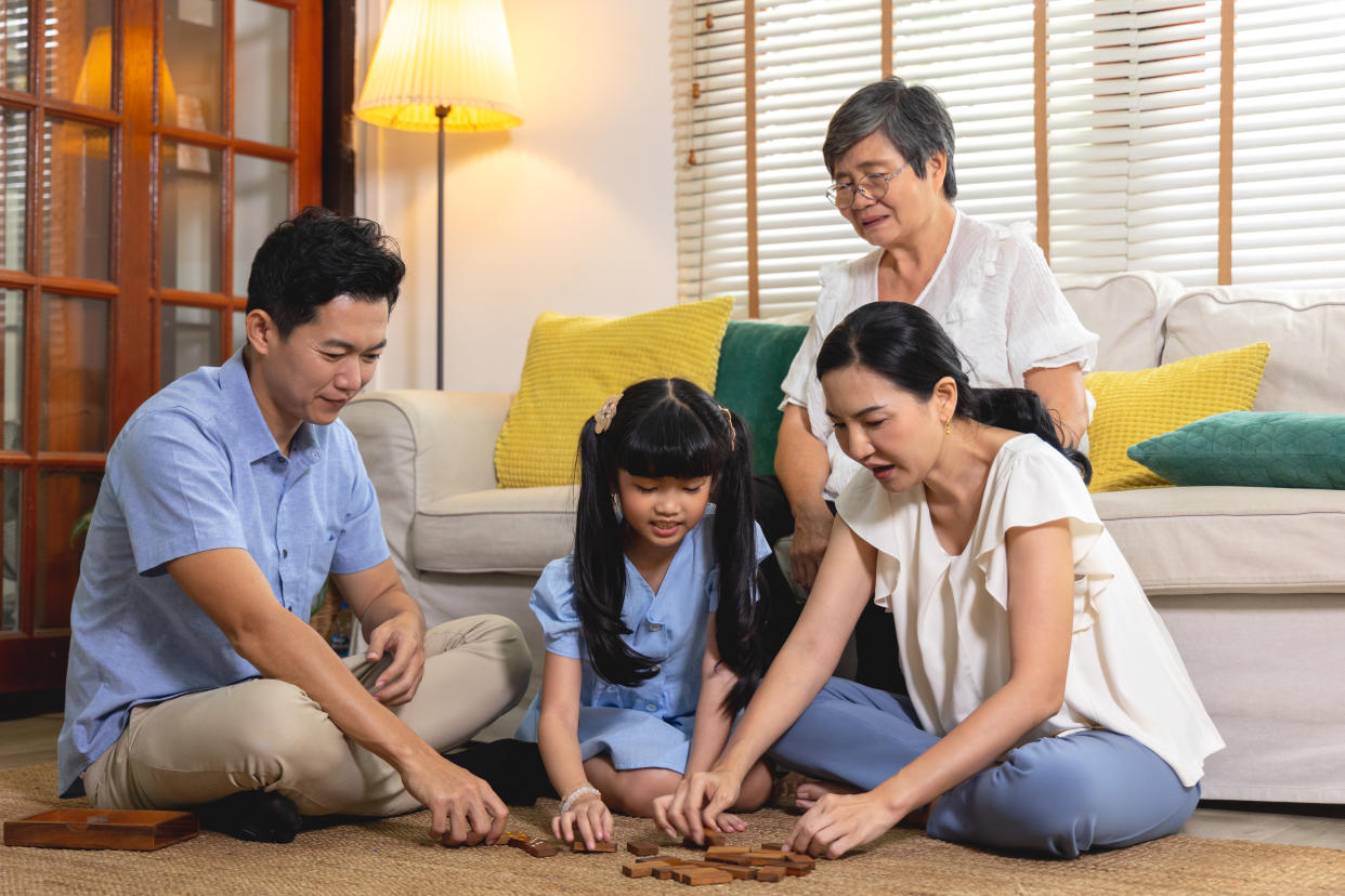 Large Happy Asian Family Gathered Together Playing Game Cards on the  floor at Home. Three Generations of Big Family Spending Time Together while Sitting on Couch in Living Room