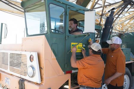 A crew at the Machinery Auctioneers lot preps equipment for an upcoming auction in Odessa, Texas June 4, 2015. REUTERS/Cooper Neill