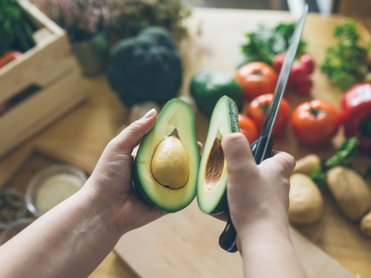 A man cutting an avocado in his kitchen (Getty Images) (Getty Images)