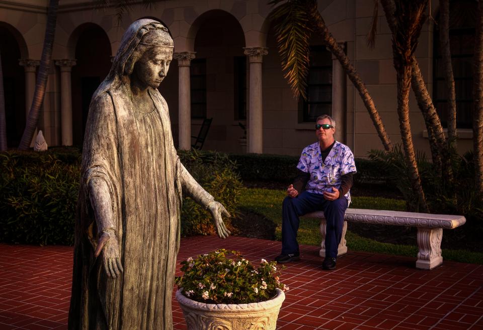 Sean GilBride stopped by St. Edward Roman Catholic Church to say a quick prayer near the statue of the Blessed Virgin Mary on Good Friday before heading off to work April 10, 2020.