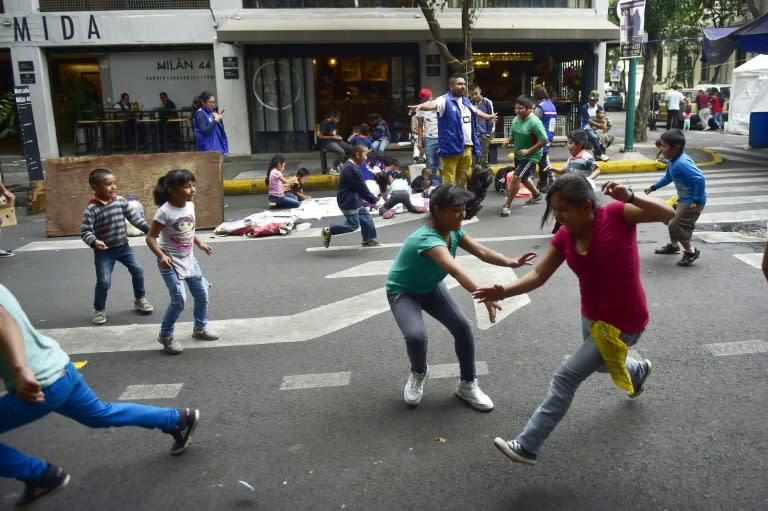 Children whose homes were seriously damaged by the September 19 quake play in a street turned into an improvised shelter in Mexico City