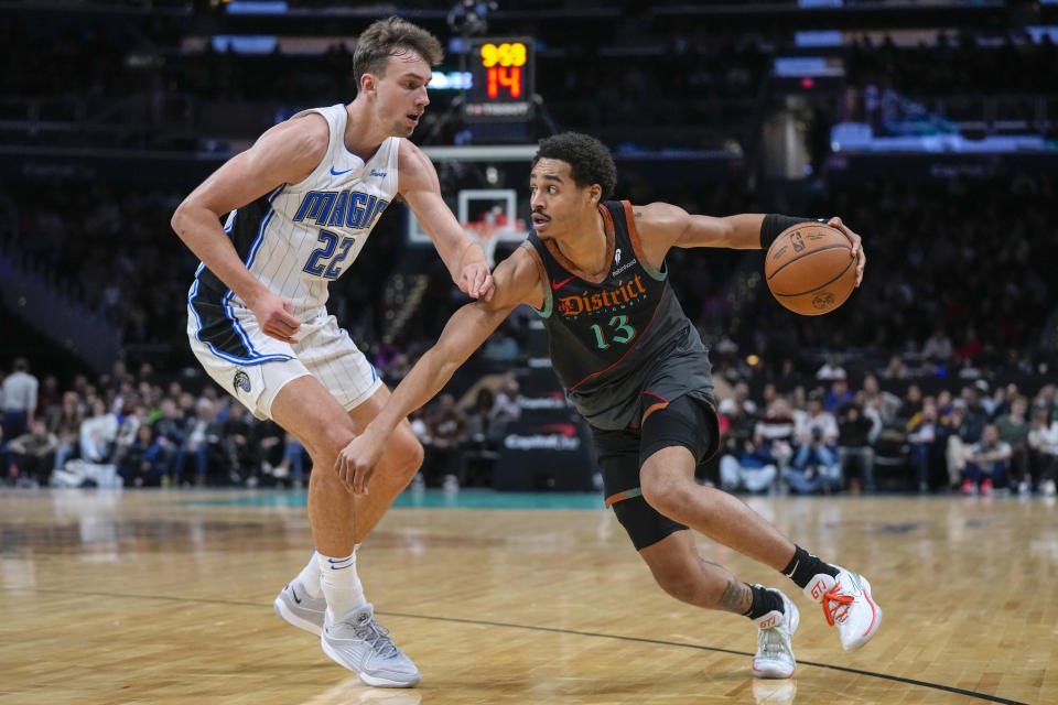 Washington Wizards guard Jordan Poole (13) works to get past Orlando Magic forward Franz Wagner (22) during the first half of an NBA basketball game Tuesday, Dec. 26, 2023, in Washington. (AP Photo/Alex Brandon)