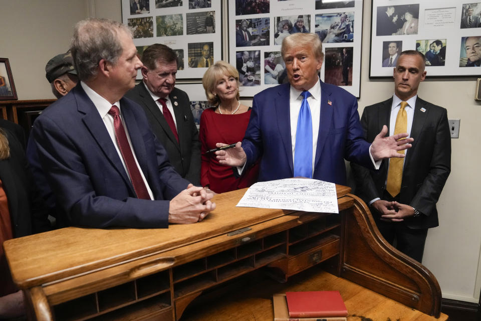 Republican presidential candidate former President Donald Trump talks as New Hampshire Secretary of State David Scanlan, left, listens as he signs papers to be on the 2024 Republican presidential primary ballot at the New Hampshire Statehouse, Monday, Oct. 23, 2023, in Concord, N.H. At right is Corey Lewandowski. (AP Photo/Charles Krupa)