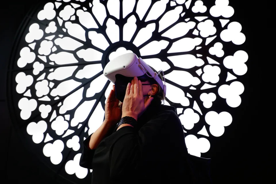 A congress attendant visiting the cathedral Notre Dame de Paris with the Meta Oculus Quest 2 headset on a virtual reality tour at the Orange stand during the Mobile World Congress (MWC) the biggest trade show of the sector focused on mobile devices, 5G, IOT, AI and big data, celebrated, on March 3, 2022 in Barcelona, Spain.  (Photo by Joan Cros/NurPhoto via Getty Images)