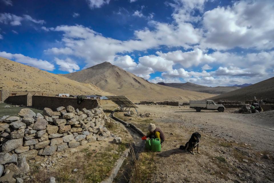 A nomad woman fetches water from a glacial trickle in remote Kharnak village in the cold desert region of Ladakh, India, Saturday, Sept. 17, 2022. Thousands of Ladakh nomads known for their unique lifestyle in one of the most hostile landscapes in the world have been at the heart of changes caused by global warming, compounded by border conflict and shrinking grazing land. (AP Photo/Mukhtar Khan)