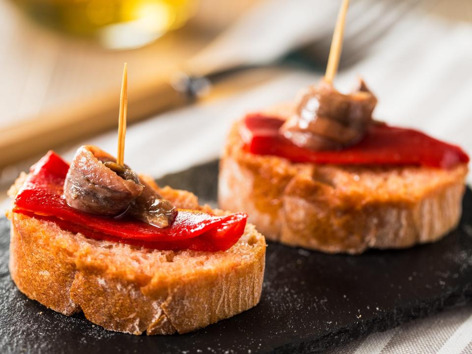 Red peppers with anchovies on a slice of bread.