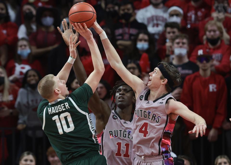 Feb 5, 2022; Piscataway, New Jersey, USA; Rutgers Scarlet Knights guard Paul Mulcahy (4) blocks a shot by Michigan State Spartans forward Joey Hauser (10) in front of center Clifford Omoruyi (11) during the second half at Jersey Mike's Arena. Mandatory Credit: Vincent Carchietta-USA TODAY Sports