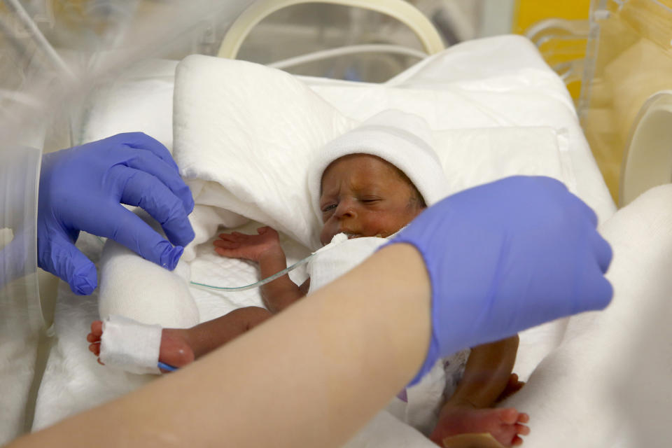 A nurse at the Casablanca Ain Borja Clinic in Morocco cares for one of nine babies born in a set of nonuplets in 2021.  (Abdeljalil Bounhar / AP)