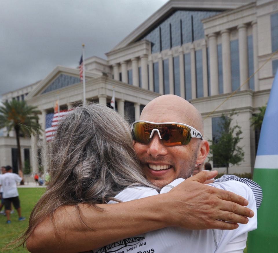Attorney Mike Freed, being hugged in this 2017 photo after finishing a six-day run from Tallahassee to raise money for Jacksonville Area Legal Aid, is using his role with a national legal organization to urge attorneys to donate time working with renters and landlords to try to resolve a backlog of pandemic-driven rent disputes without mass evictions.