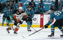 Anaheim Ducks right wing Carter Rowney (24) sends the puck down ice past San Jose Sharks defenseman Nicolas Meloche (53) during the second period of an NHL hockey game in San Jose, Calif., Monday, Feb. 15, 2021. (AP Photo/Tony Avelar)