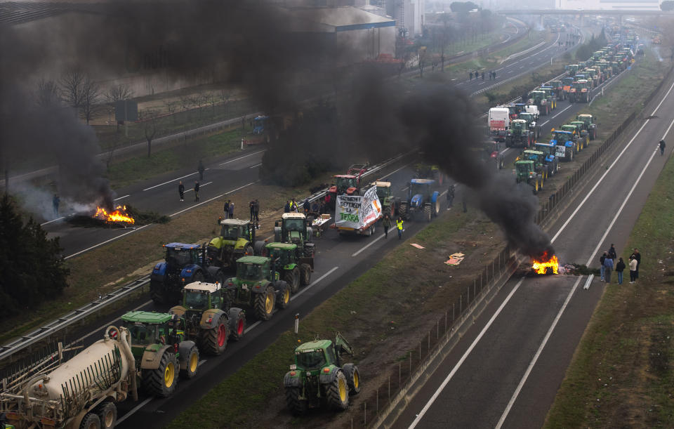 Farmers make barricades after blocking a highway during a protest near Mollerussa, northeast Spain, Tuesday, Feb. 6, 2024. From early morning, farmers across Spain have staged tractor protests across the country, blocking highways and causing traffic jams to demand changes in European Union policies and funds and measures to combat production cost hikes. (AP Photo/Emilio Morenatti)