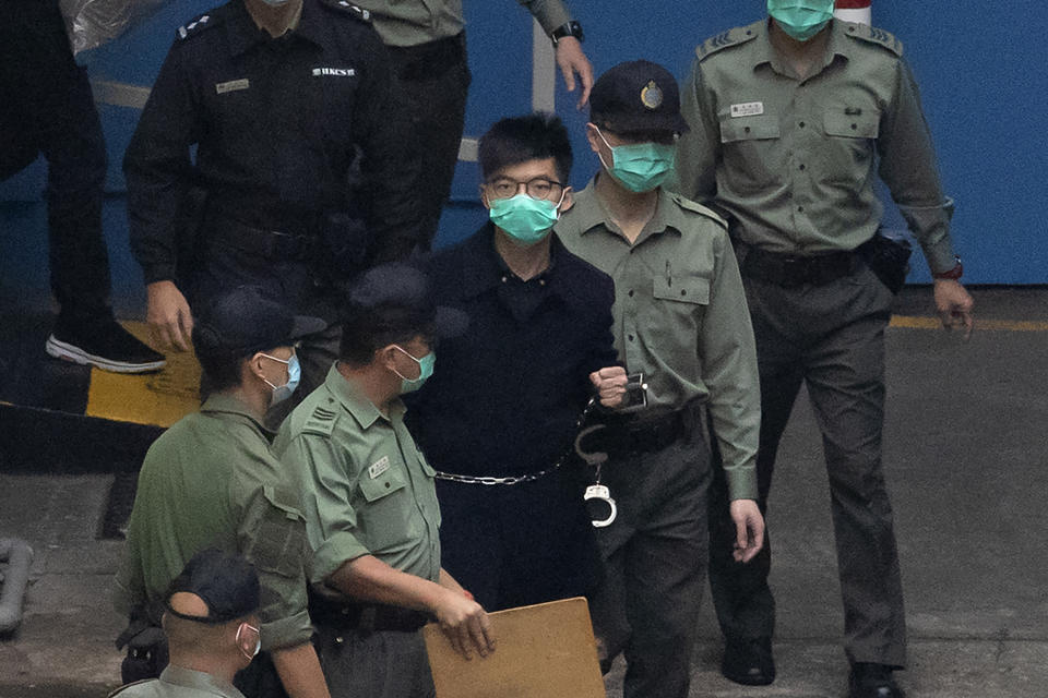 In this March 4, 2021, file photo, Hong Kong activist Joshua Wong, one of the 47 pro-democracy activists is escorted by Correctional Services officers to a prison van in Hong Kong, A national security law enacted in 2020 and COVID-19 restrictions have stifled major protests in Hong Kong including an annual march on July 1. (AP Photo/Kin Cheung, File)