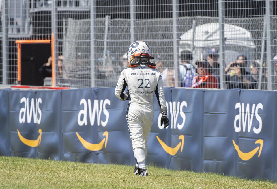Alpha Tauri driver Yuki Tsunoda, of Japan, walks back to the pits after crashing at the the Senna Corner during the Canadian Grand Prix auto race in Montreal, Sunday, June 19, 2022. (Graham Hughes/The Canadian Press via AP)