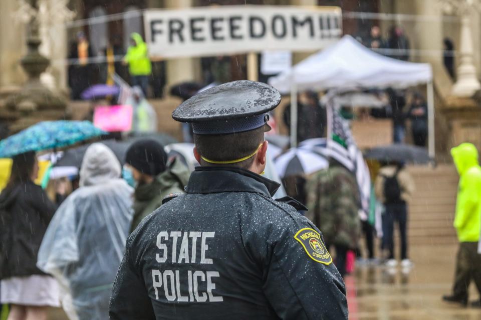 Michigan State Police look on during the a protest rally against Gov. Gretchen Whitmer's order to stay home during COVID-19 pandemic in Lansing, Mich. on Thursday, May 14, 2020. 