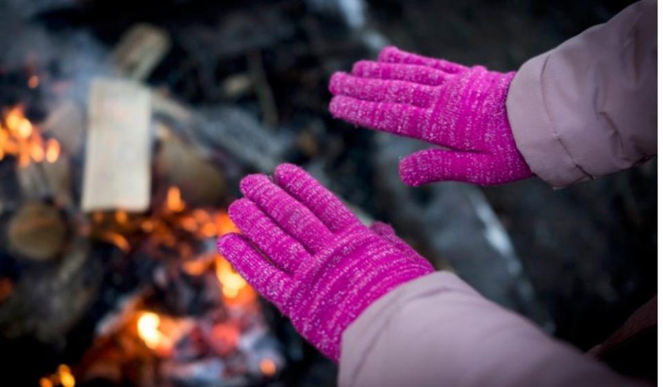 hands in mittens over campfire