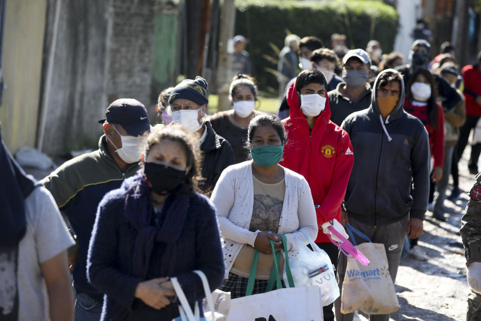 Una fila de personas espera el reparto de comida realizado por soldados durante la cuarentena ordenada por el gobierno para frenar la propagación del coronavirus, en Buenos Aires, Argentina, el 29 de abril de 2020. (AP Foto/Natacha Pisarenko)