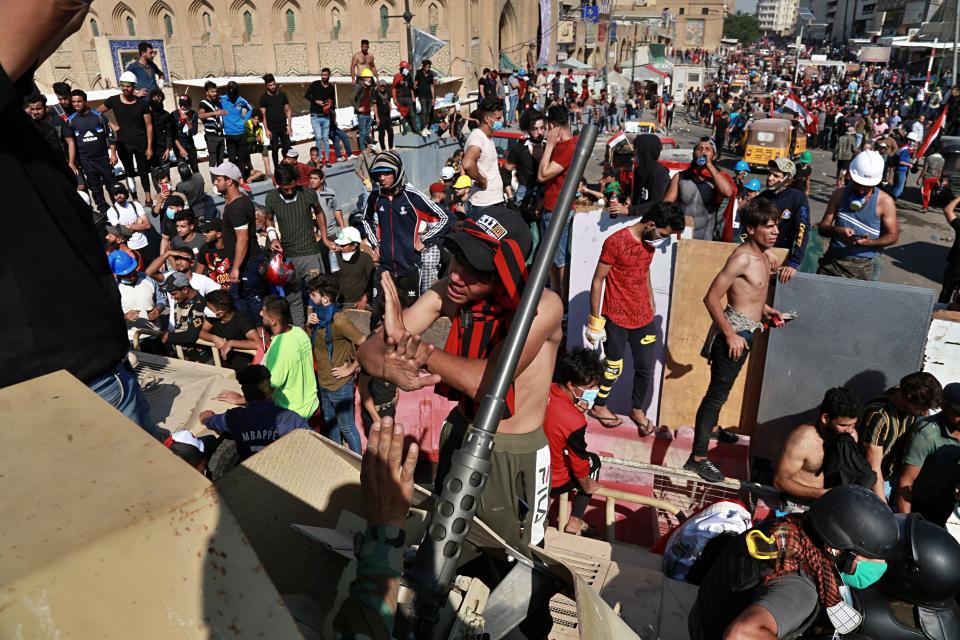 The Iraqi Army soldiers try to prevent protesters from crossing the al- Shuhada (Martyrs) bridge in central Baghdad, Iraq, Wednesday, Nov. 6, 2019. (AP Photo/Khalid Mohammed)