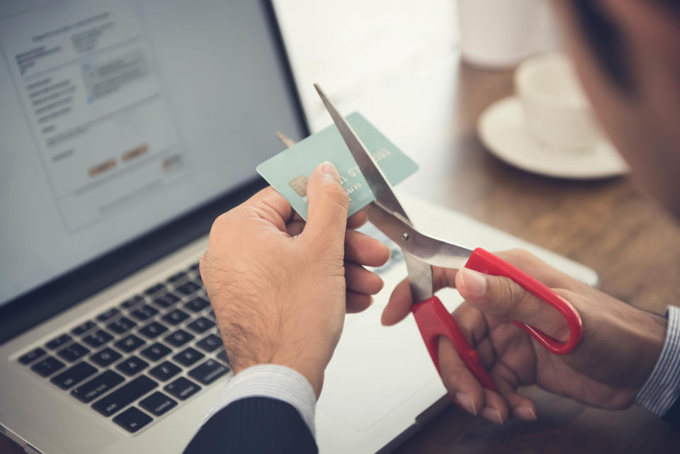 Businessman cutting a credit card in a bid to save money?