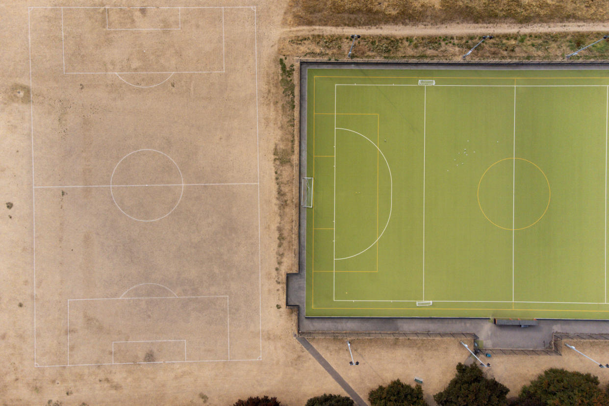 Parched grass surrounds artificial grass at St Nicholas' Park in Warwick, as the UK braces for three days of rain and yellow weather warnings. Picture date: Monday August 15, 2022.