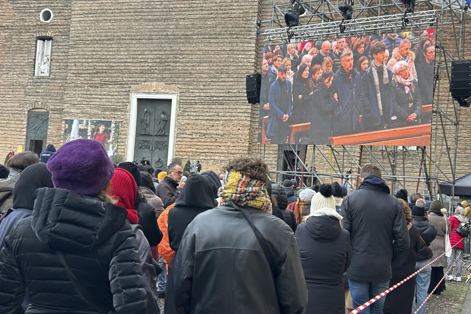 People watch on a screen the funeral of Giulia Cecchettin, outside the Church of Santa Giustina in Padua, Italy, Tuesday Dec. 5, 2023. Mourners gathered at the Church of San Giustina in Padua for the funeral of Giulia Cecchettin, the 22-year-old killed by her former boyfriend, 21-year-old Filippo Turetta, on Nov. 11. (Lucrezia Granzetti/LaPresse via AP)