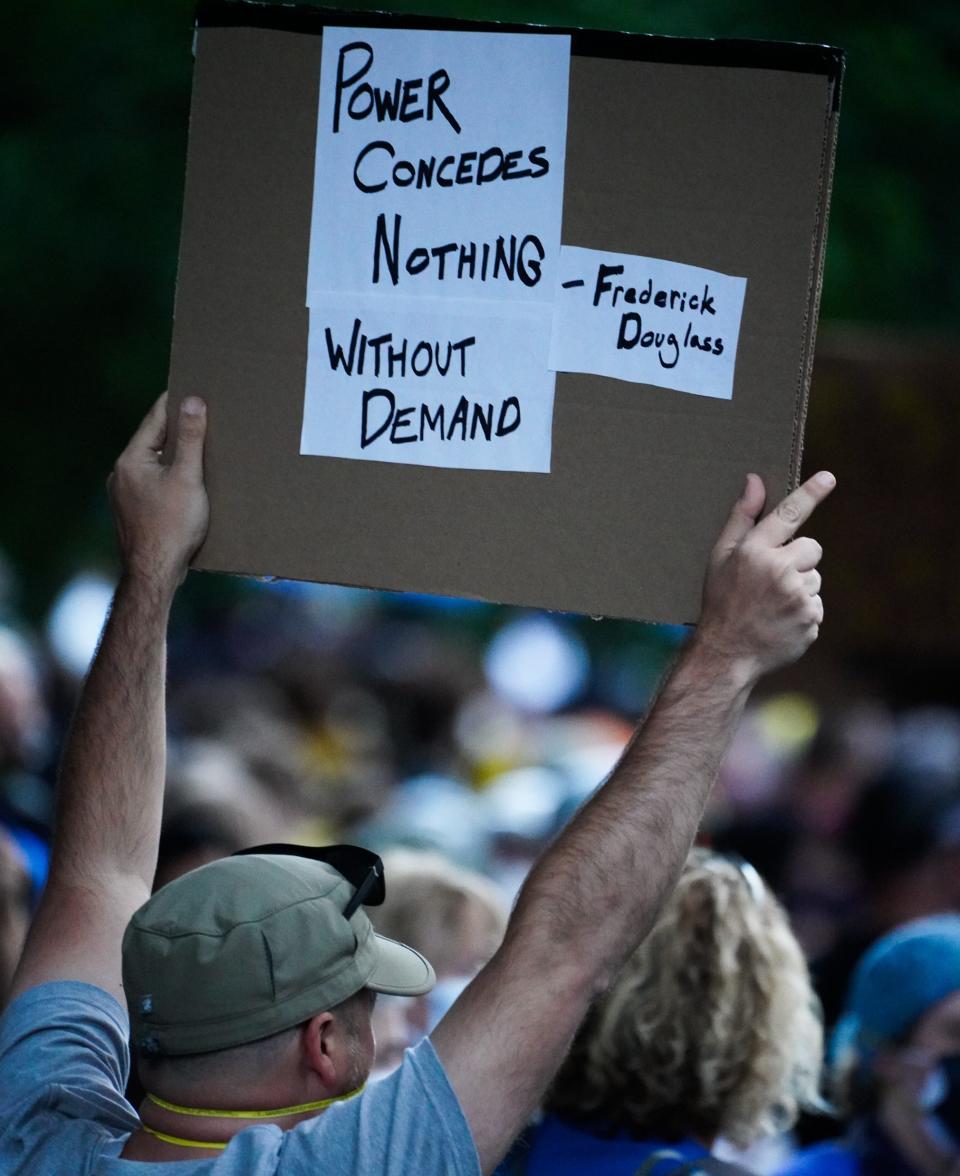 A man participating in a Black Lives Matter protest holds a sign in Portland, Oregon, on July 26, 2020.