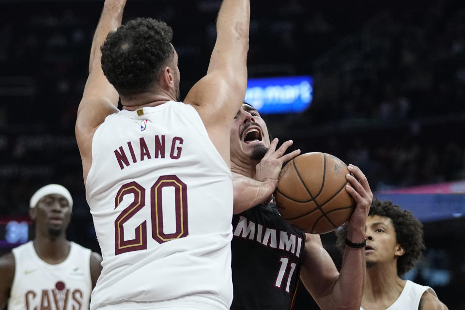 Miami Heat guard Jaime Jaquez Jr. (11) collides with Cleveland Cavaliers forward Georges Niang (20) during the first half of an NBA basketball game Wednesday, Nov. 22, 2023, in Cleveland. (AP Photo/Sue Ogrocki)