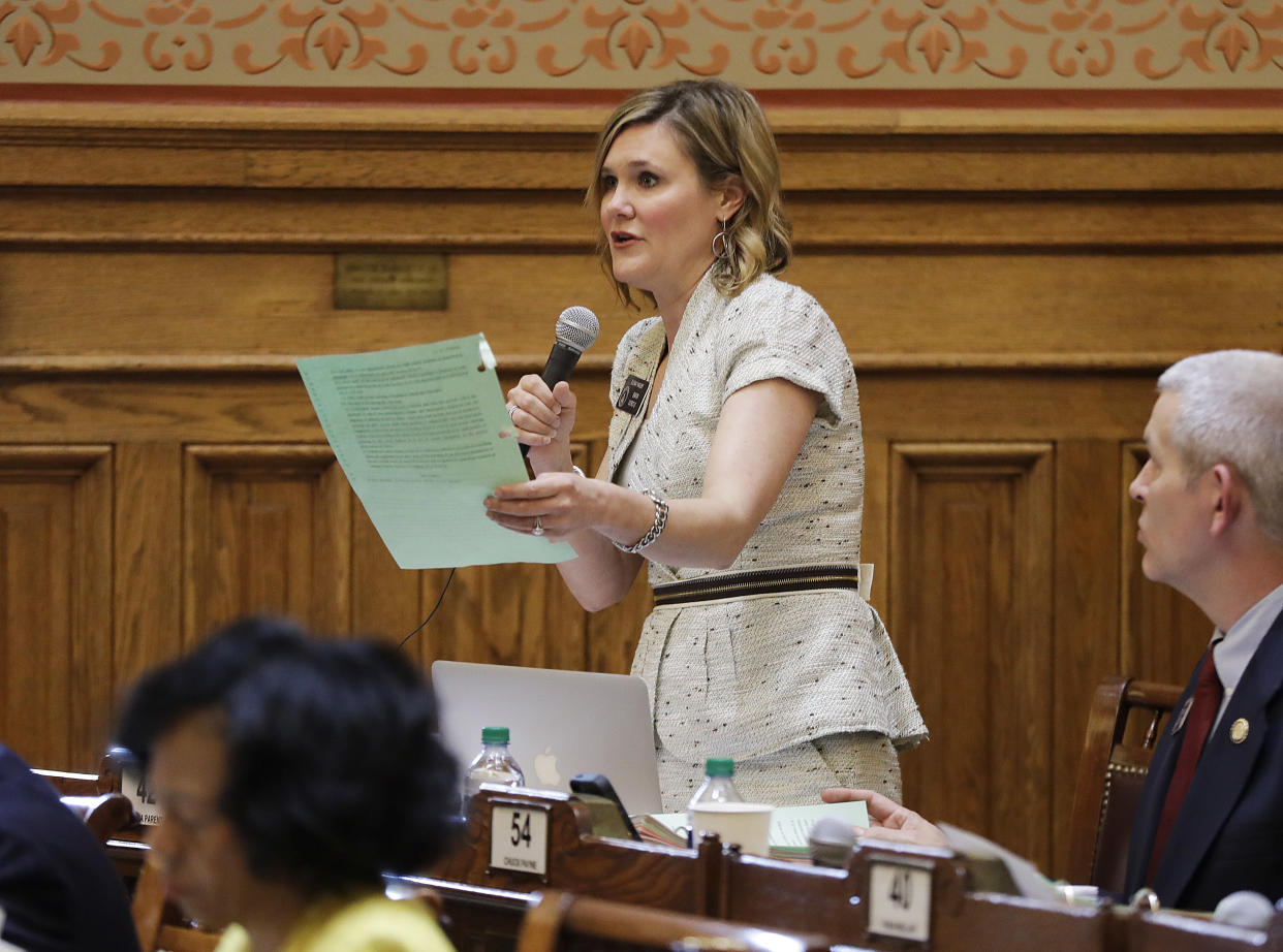 Georgia Senator Elena Parent stands as she speaks into a microphone during a meeting.