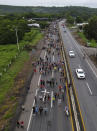 Migrants, many from Central American and Venezuela, walk along the Huehuetan highway in Chiapas state, Mexico, early Tuesday, June 7, 2022. The group left Tapachula on Monday, tired of waiting to normalize their status in a region with little work and still far from their ultimate goal of reaching the United States. (AP Photo/Marco Ugarte)