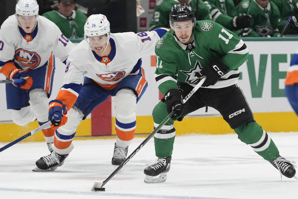 Dallas Stars center Logan Stankoven (11) moves the puck in front of New York Islanders left wing Pierre Engvall (18) and right wing Simon Holmstrom (10) during the first period an NHL hockey game in Dallas, Monday, Feb. 26, 2024. (AP Photo/LM Otero)