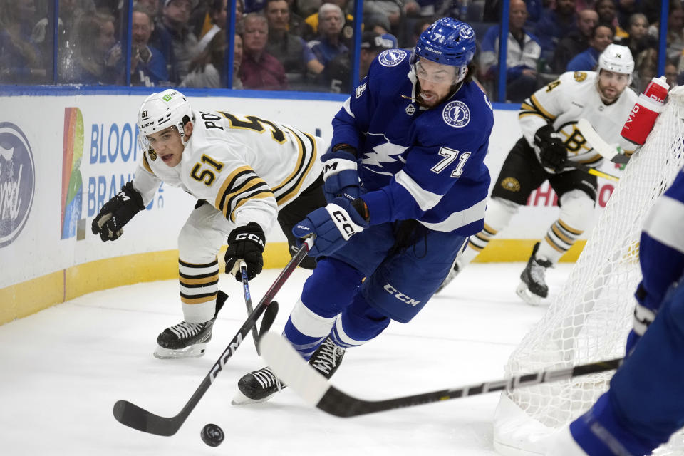 Tampa Bay Lightning center Anthony Cirelli (71) moves the puck ahead of Boston Bruins center Matthew Poitras (51) during the first period of an NHL hockey game Monday, Nov. 20, 2023, in Tampa, Fla. (AP Photo/Chris O'Meara)