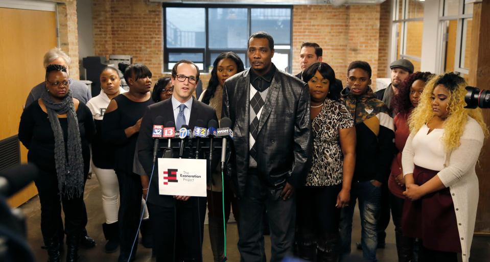 Keith Cooper, 49, center, is surrounded by his attorney, Elliot Slosar, center left, along with family and friends during a news conference Friday, Feb. 10, 2017, in Chicago, after new Indiana Gov. Eric Holcomb granted Cooper a pardon Thursday. Cooper, who was released in 2006, spent more than eight years in prison for a wrongful conviction and says he's angry his name wasn't cleared by Vice President Mike Pence during his time as Indiana governor.