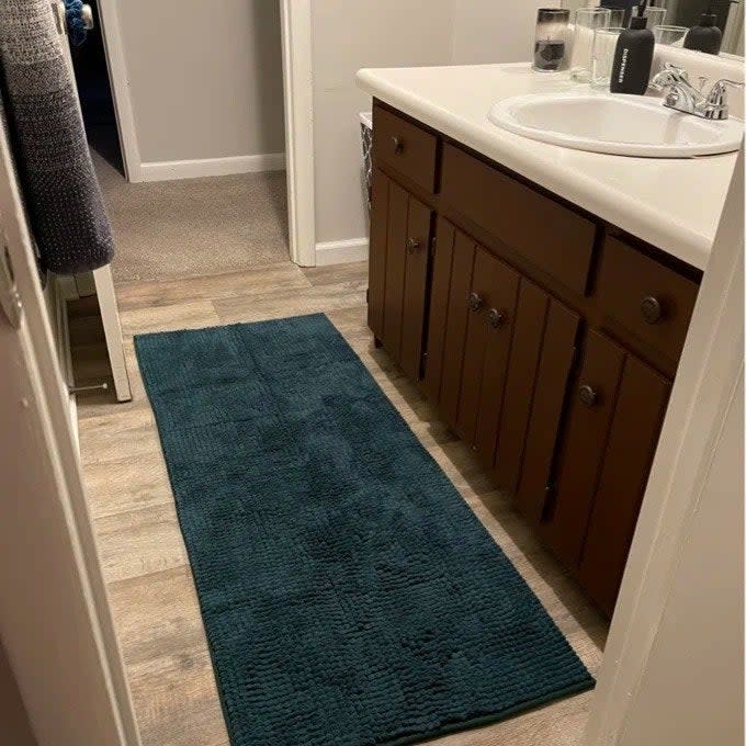 A reviewer photo of a large mat beneath a double sink