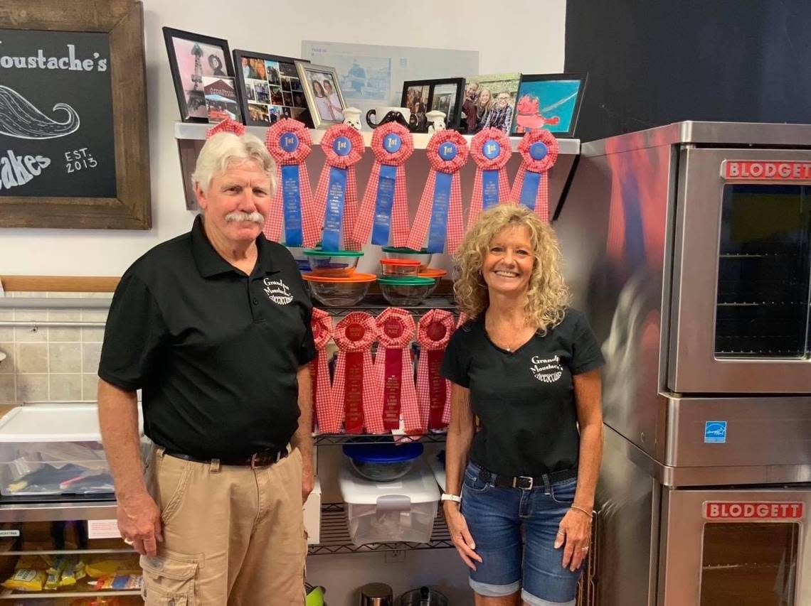 Peter Brown and his wife, June, stand with the many ribbons he has won over the years for his cheesecakes. The Little River couple will open Grandpa Moustache’s Cheesecakes this fall in North Myrtle Beach.