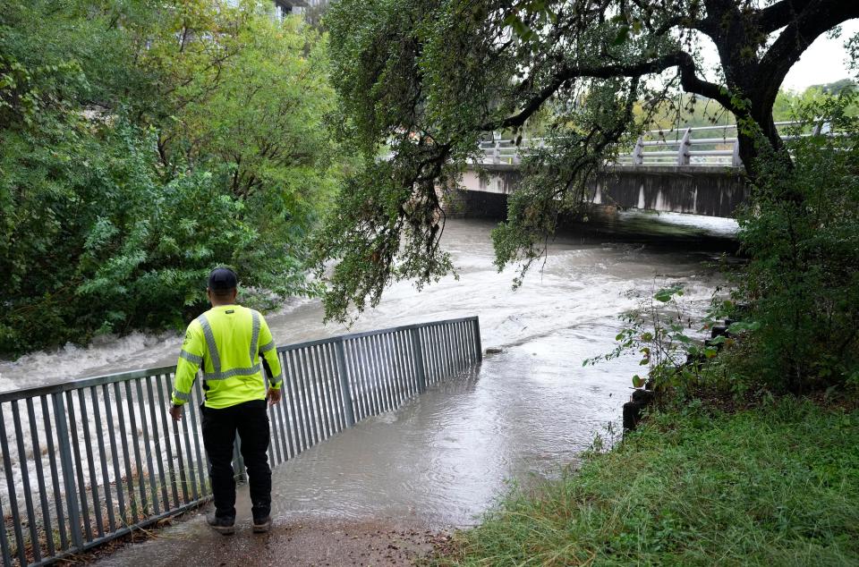 Mario Roja, of the City of Austin Watershed Protection Department, looks at Shoal Creek at West 9th Street during a rain storm on Thursday October 26, 2023.