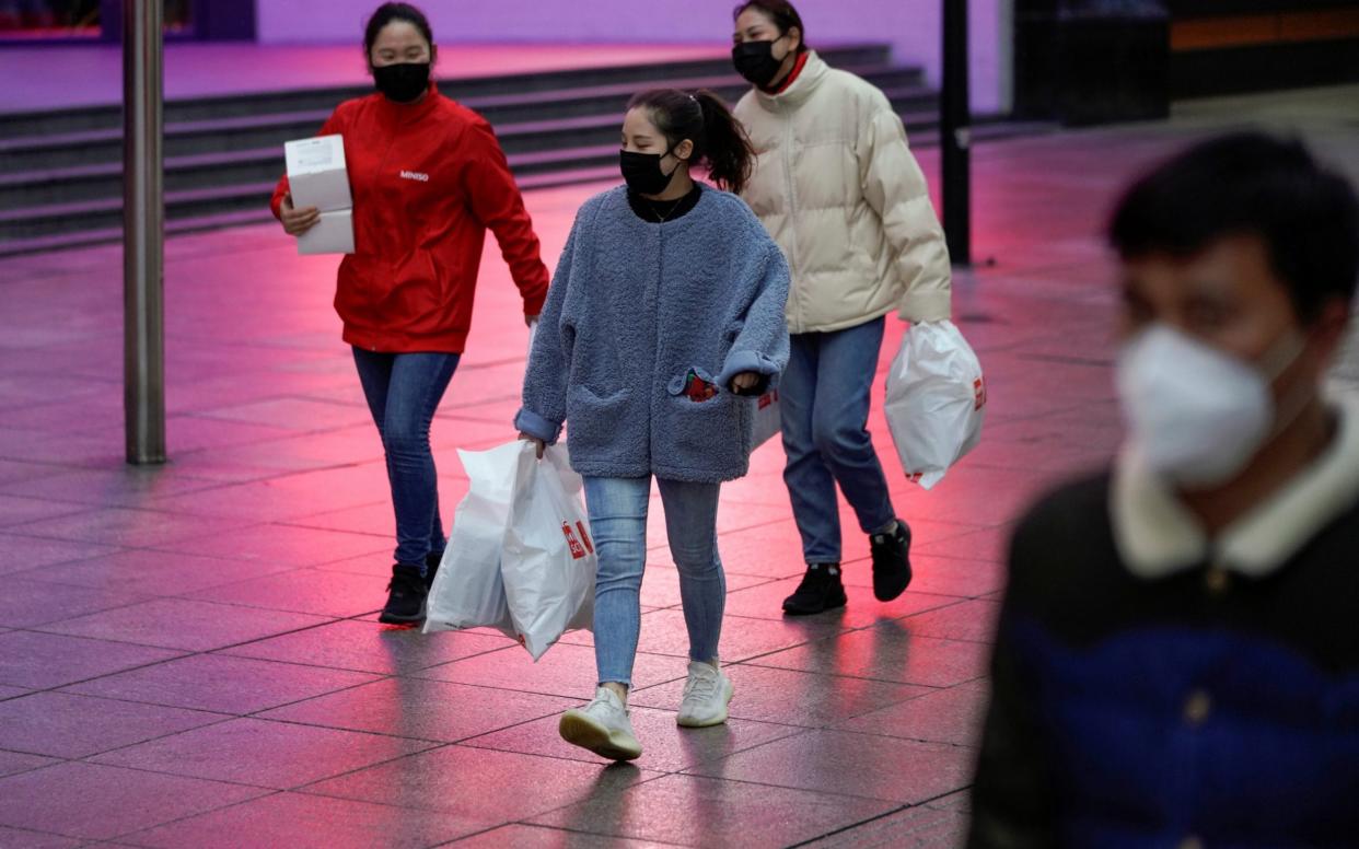 People wear masks at a main shopping area, in downtown Shanghai - ALY SONG / REUTERS