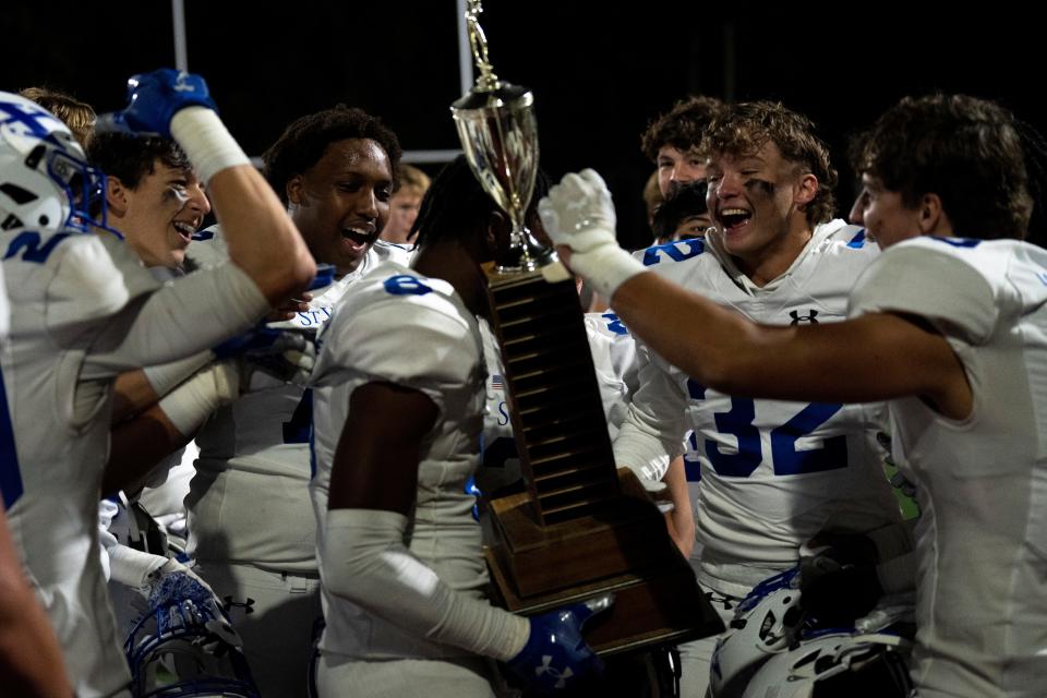 St. Xavier defensive back Robert Houston (6) holds the North Bend trophy as St. Xavier defensive back Drew Patterson (32) celebrates with him after the OHSAA football game between La Salle and St. Xavier at La Salle High School in Monfort Heights on Friday, Oct. 7, 2022. 