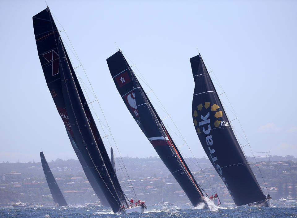 Maxi yachts Wild Oats XI, left, Scallywag and Infotrack, right, leave the heads during the start of the Sydney Hobart yacht race in Sydney, Wednesday, Dec. 26, 2018. The 630-nautical mile race has 85 yachts starting in the race to the island state of Tasmania. (AP Photo/Rick Rycroft)