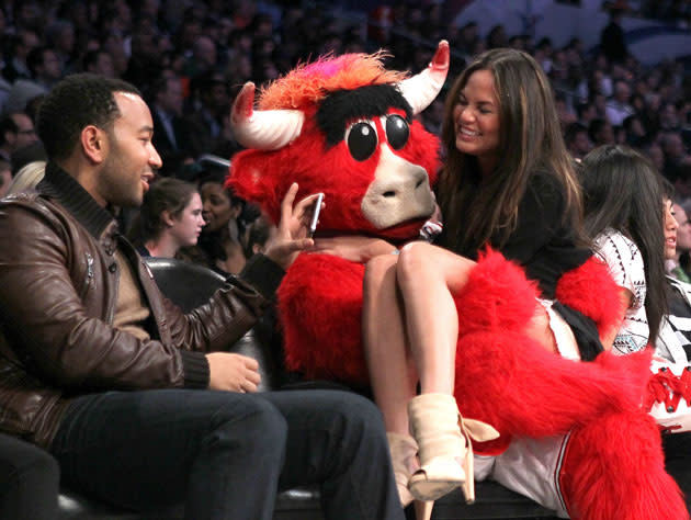 Benny the Bull, the Barry Anderson version, visits with John Legend and Chrissy Teigen. (Getty Images)