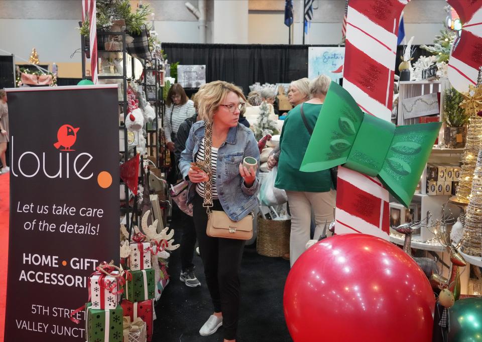 Tiffany Ehler of West Des Moines peruses craft items at the Louie booth during the Holiday Boutique at the Iowa Events Center on Friday, Nov. 4, 2022, in Des Moines.