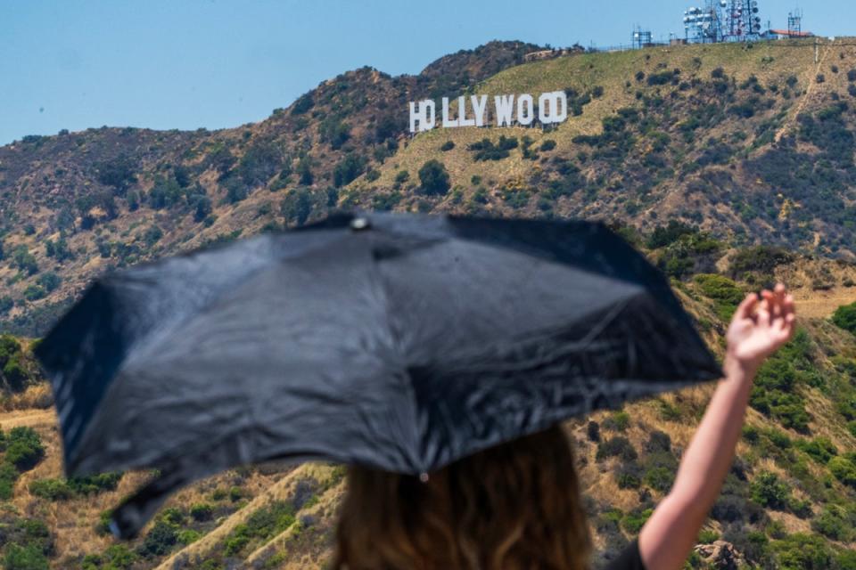 Tourists take pictures under an umbrella at the Griffith Observatory in Los Angeles during the 2023 heatwave. A new heat wave is hiting the West Coast this week with many areas expected to see tempatures over 100 degrees. (AP)