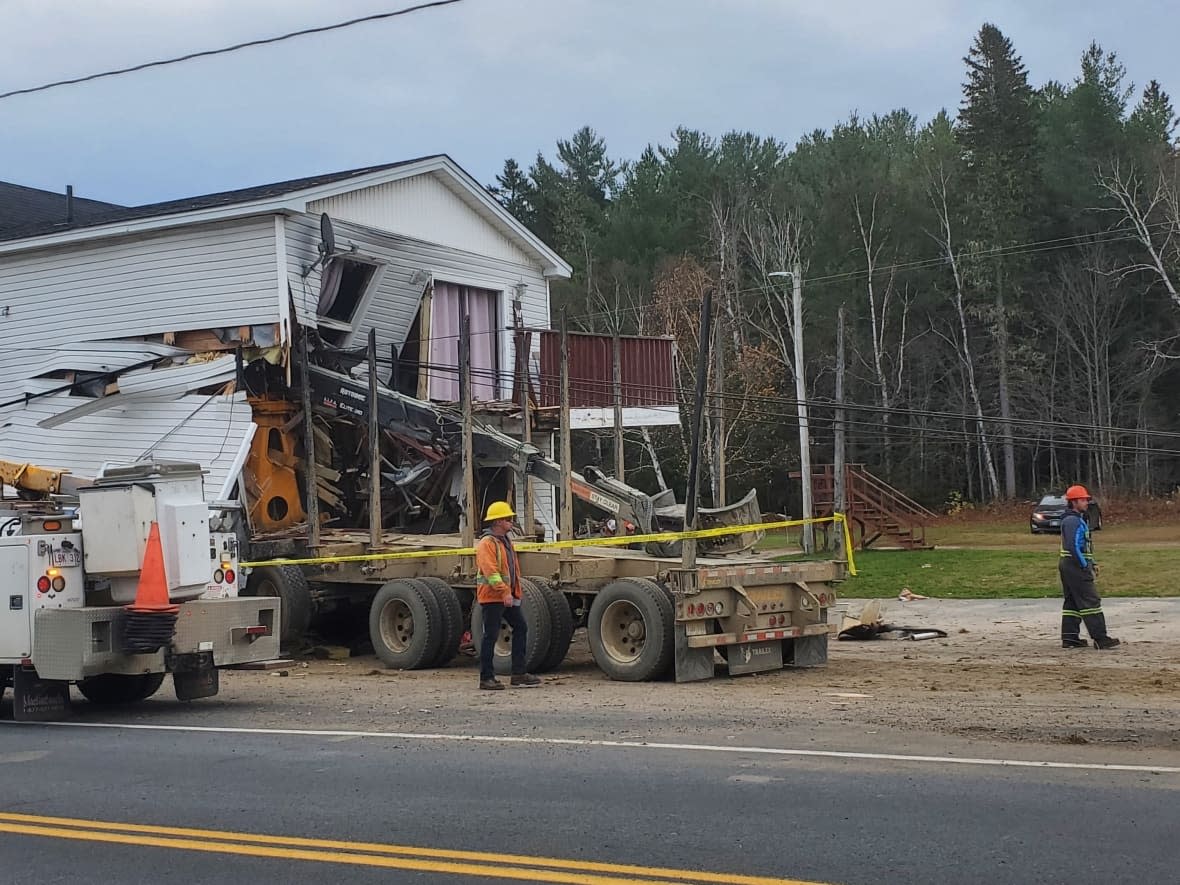 A logging truck crashed into the side of an apartment building in Ludlow, about 71 kilometres north of Fredericton, in the early hours of Oct. 24. (Shane Fowler/CBC - image credit)